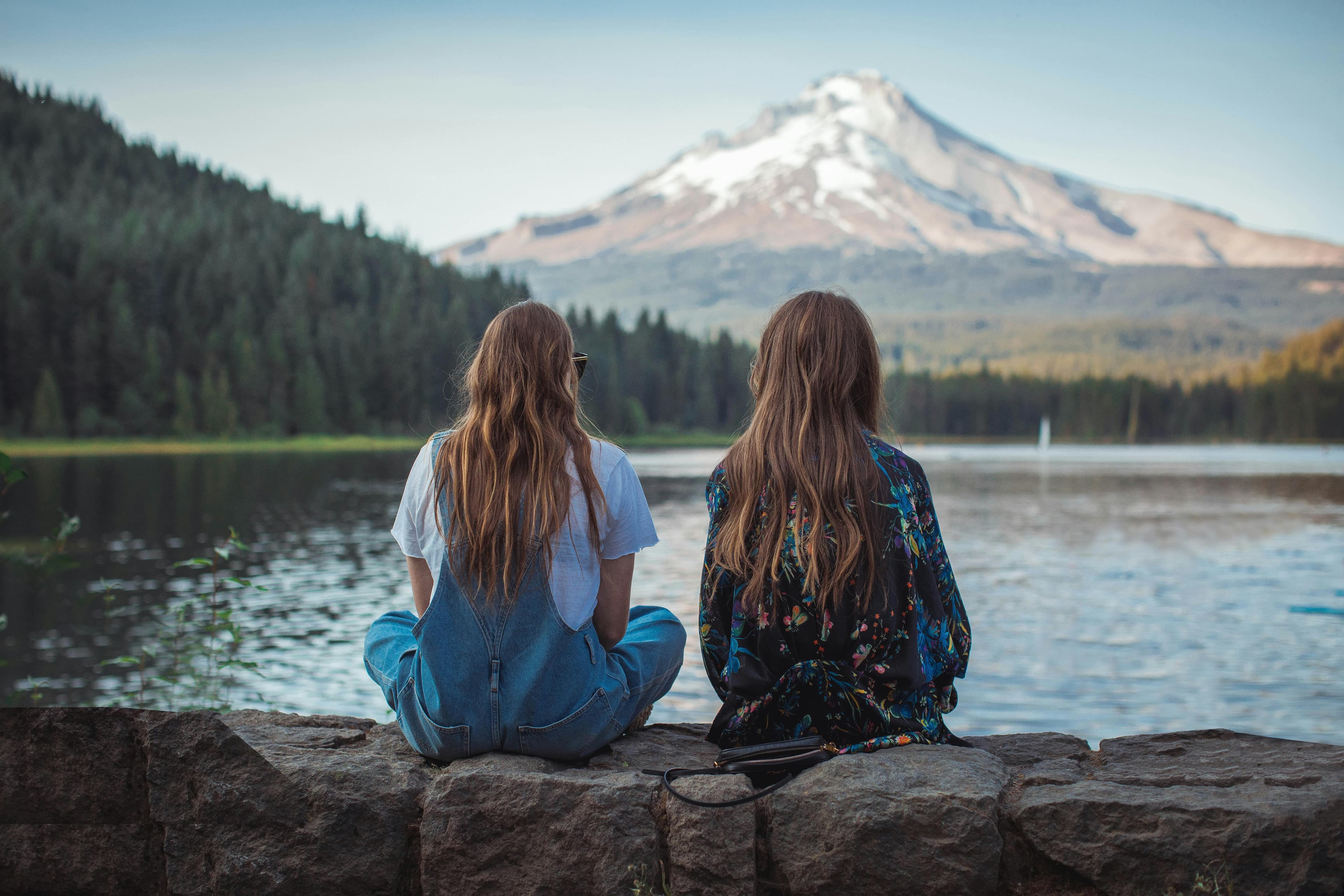 Person sitting quietly in peaceful natural setting, representing trauma healing and the journey from past experiences to present wellness